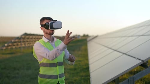 Male Worker in VR Headset Standing Field with Solar Panels