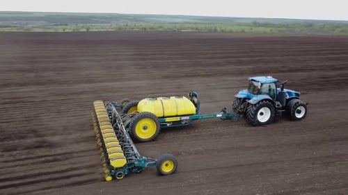 Blue tractor OA working on the field in Ukraine