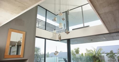 Modern living room with large windows overlooking pool and outdoor seating area, at home