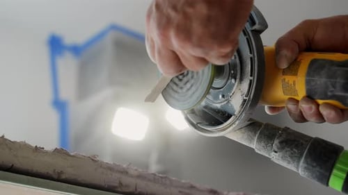 Worker Smoothing a Ceramic Tile Angle with Tile Cutter on Workbench During a Home Renovation Project