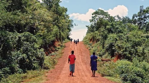 People Walking on a Path Through Rural Countryside