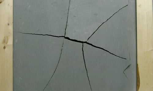 Impact Collection: Effect of a crack expanding very slowly from the center of grey concrete tile