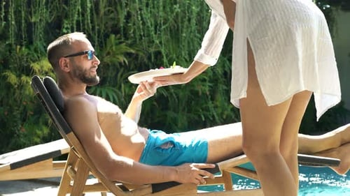 Man relaxing at pool gets breakfast in luxury