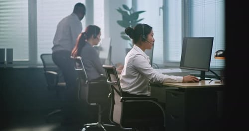 Multiethnic Team of Technical Support Operators Working in Modern Call Center Office