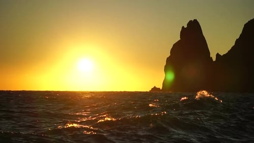 Red Burning Sunset Over Stormy Sea with Rocky Volcanic Cliff Abstract Nature Ocean Sea Background