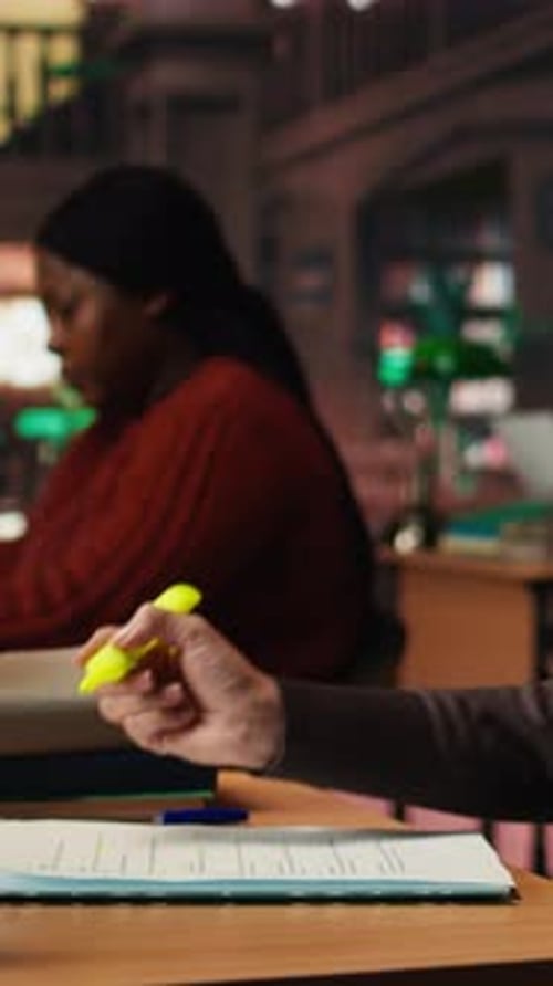 Vertical Video Aged Woman Studying in a Campus Library with Highlighter Pen on Materials