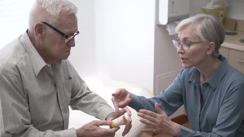Senior man receives prescription information from woman doctor