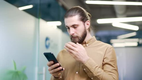 Man Using Smartphone in Modern Office Setting