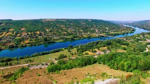 Picturesque village on the waterfront of narrow river. Bridge crossing the river. Blue sky backdrop.