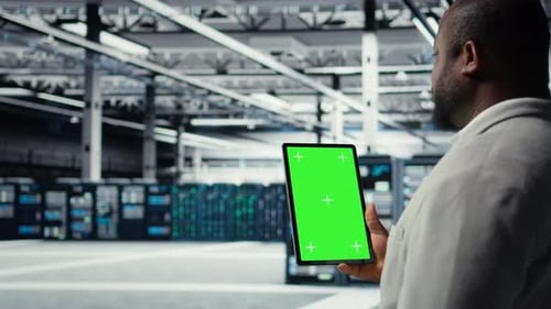 Admin Working in Server Farm Using Isolated Screen Tablet to Analyze Data