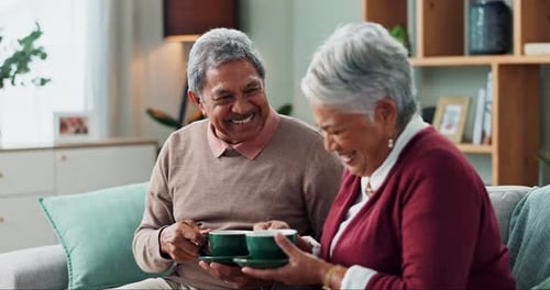 Smiling Elderly Couple Chatting and Drinking Coffee Indoors