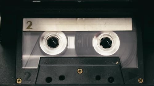 Tape recorder cassette rewind action, stops then plays media CLOSE-UP