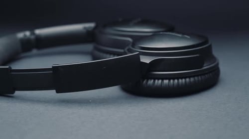 headphones on a dark background, moving the camera from right to left.