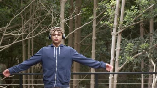 Man in Headphones Meditates Outdoors in Forest