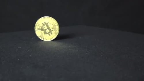 Reflektierende Bitcoin-Münzen drehen sich in Zeitlupe und Tropfen auf einer dunklen Oberfläche und einem dunklen Hintergrund.