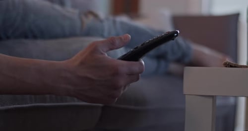 Man Lying on Couch Watching Television