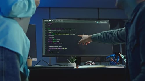 Entwickler zeigt während des Code-Reviews auf den Programmcode auf dem Monitor