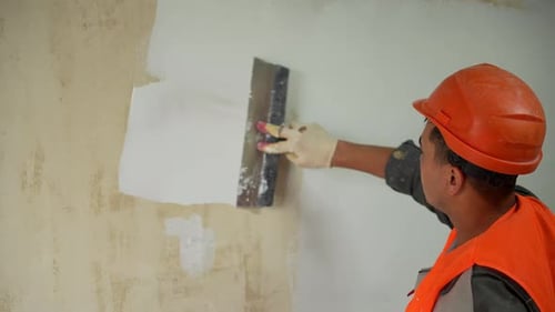 Close Up of Worker Applying Plaster with Trowel on Wall