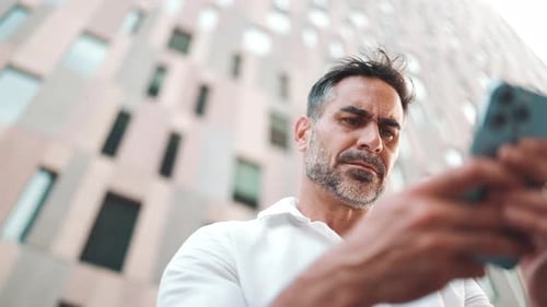 Man Uses Phone in the City, Close Up