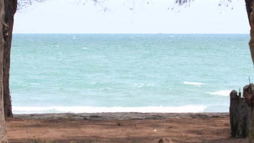 Tranquil Beach Scene with Clear Turquoise Waters Viewed Between