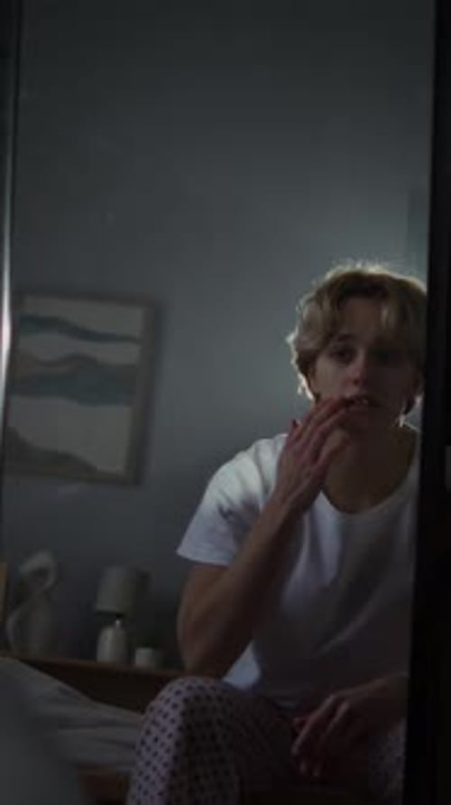 Man in Pajamas Ponders Thoughts in Bedroom