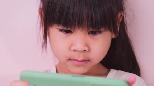 Little Girl Focused on Mobile Phone Screen