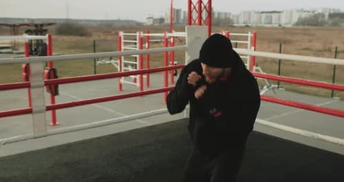 Young Adult Boxer Practices Punches Outdoors