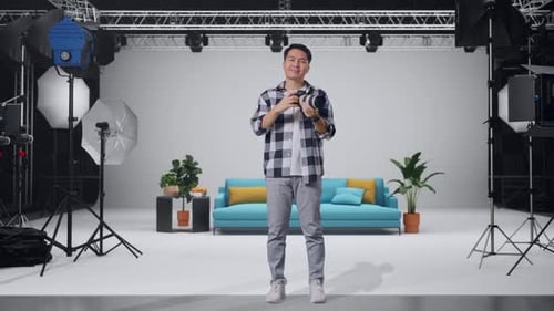Asian Photographer Using A Camera Taking Pictures And Smiling In The Studio