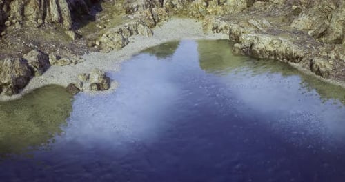 Clear Water Reflects Rocky Shoreline in Serene Natural Setting