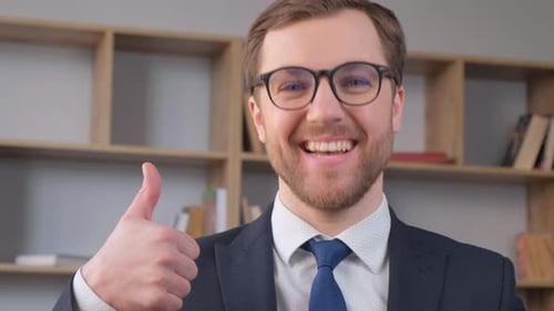 Businessman Showing Thumbs Up with One Hand While Smiling While Standing in the Middle of the Office