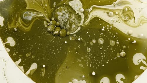 Bubbles exploding in green liquid paint