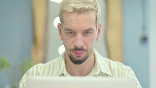 Close Up of Young Man Reacting to Loss on Laptop