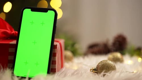 Smartphone with Green Screen Near Festive Gift Box
