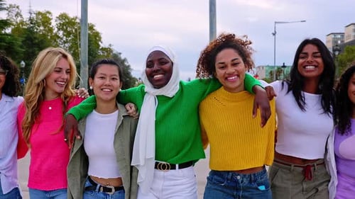 Vista frontal de mulheres jovens e diversas se abraçando caminhando juntas ao ar livre