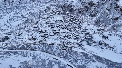 Aerial drone shot showcasing a winter wonderland as a city is fully covered in deep snow