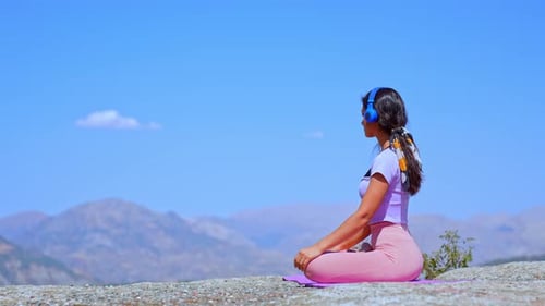 Woman Practicing Yoga Balance Pose on Cliff with Mountain View