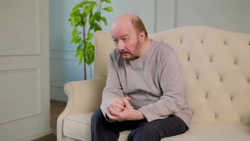 Man Speaking While Sitting on Couch Inside