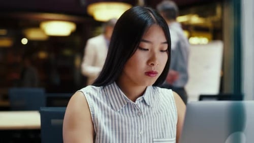 Asian Woman Working on Laptop in Office