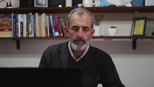 Mature man works from home with his laptop