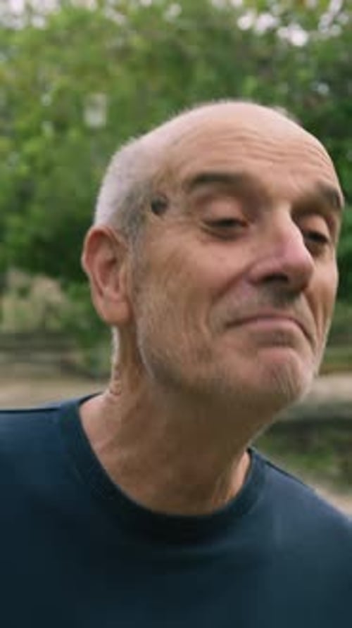 Elderly Man Smiles At An Intrigued Child In The Nature Park Outside