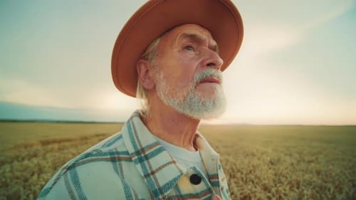 Contemplative Farmer Standing in Golden Wheat Field