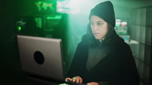 Young Adult Typing on Laptop in Dark Room