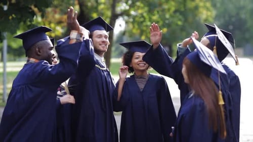 Graduates celebrate together after graduation on campus