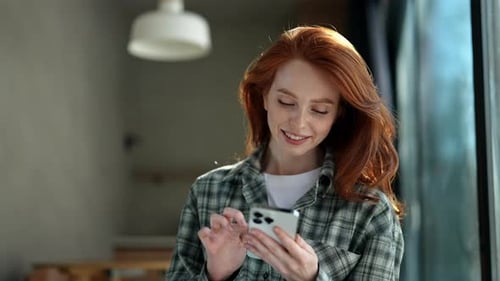 Smiling Woman Using Mobile Phone Indoors