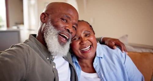 Senior Couple Laughing Together on Couch