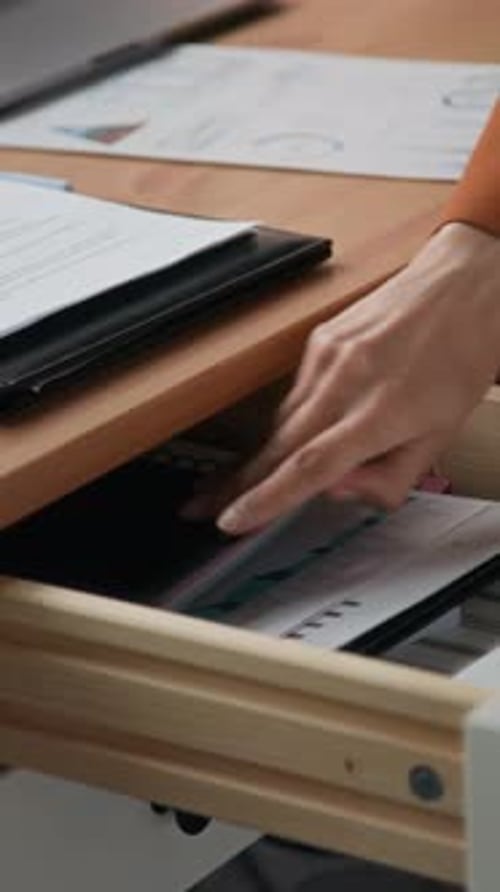 Office Worker Retrieving Highlighter from Desk Drawer During Paperwork