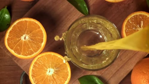 Pouring Fresh Orange Juice in Glass Close-Up