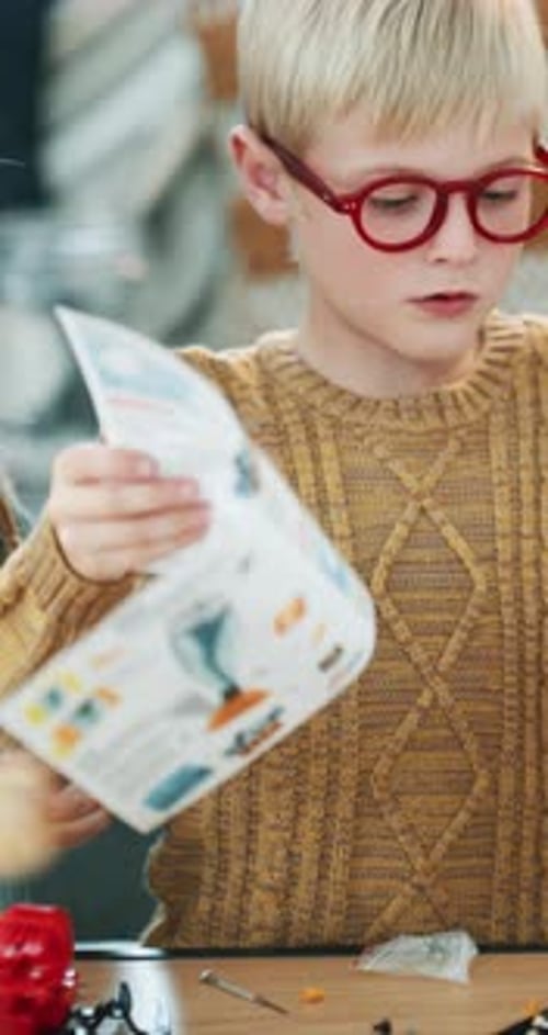 Child, reading and manual in home for project, education and demonstration on science craft