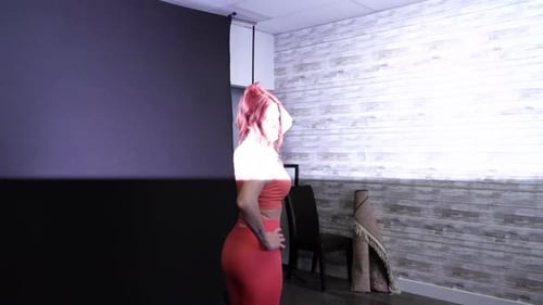 Young Woman Posing in Coral Sportswear in Studio