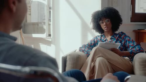 Woman Therapist Talking to Patient in Sunny Office